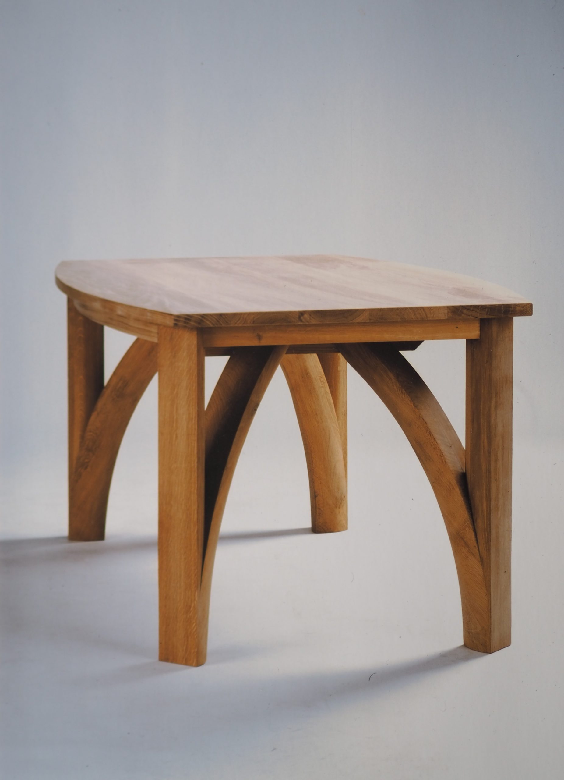 English oak Gothic inspired dining table. hand shaped legs below a convex solid top.