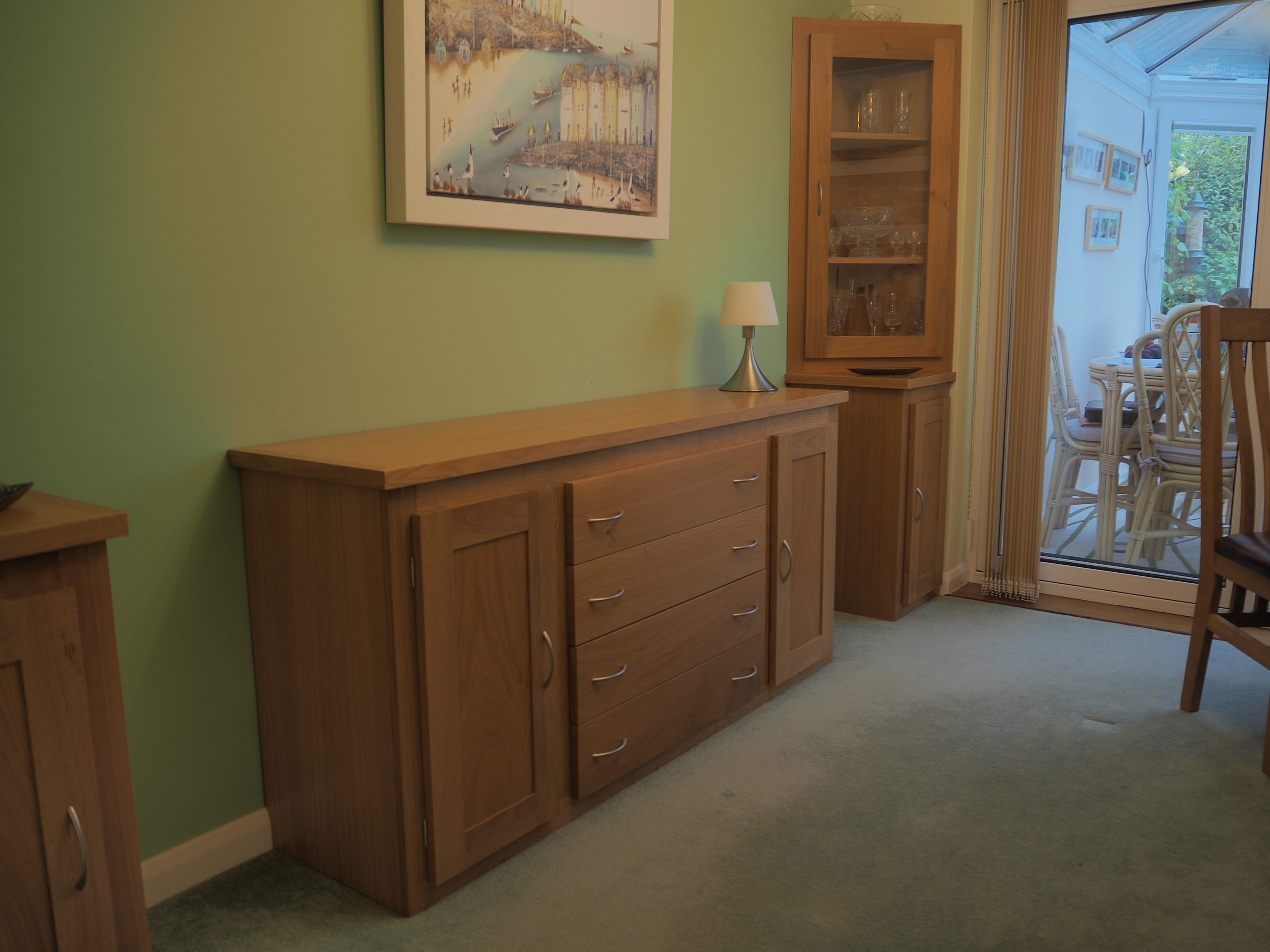 Dinning room sideboard with complementing display cabinets. Three draw Twin cupboard sideboard made in Oak with satin nickel handles. A Pair of glass fronted accompanying corner display cabinets.